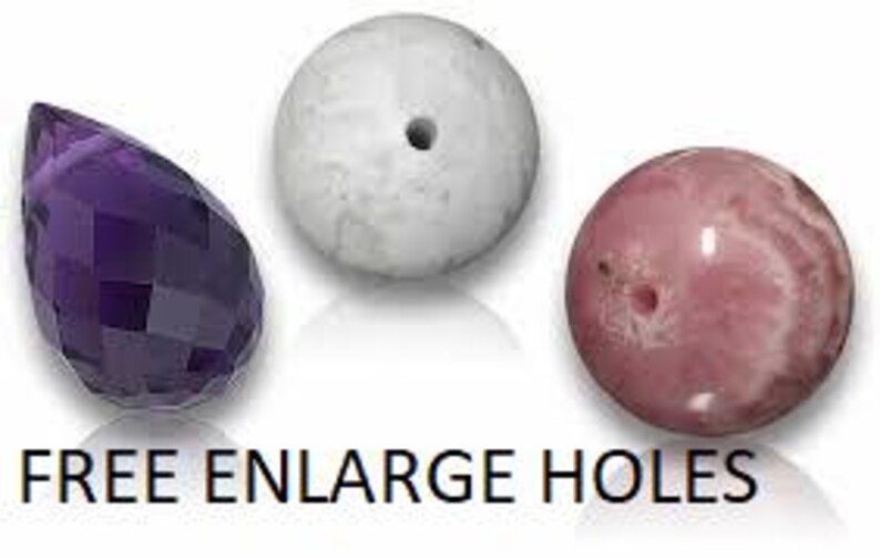 May include: Three beads including a faceted purple teardrop bead, a smooth white spherical bead with a center hole, and a smooth pink spherical bead with a visible hole. The text FREE ENLARGE HOLES is printed in black at the bottom of the image.