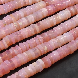 May include: A strand of pink opal beads, each bead is a stack of small, flat, rounded, and slightly irregular shaped beads. The beads are a pale pink colour with a slight iridescent sheen.