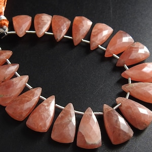 Puede incluir: Una hebra de 20 cuentas de piedra preciosa facetadas, de color rosa y en forma de lágrima. Las cuentas están enhebradas en un alambre de plata.