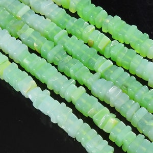 Könnte beinhalten: Eine Strähne aus hellgrünen Edelsteinperlen, jede Perle ist ein rechteckiger Prisma mit leicht abgerundeten Kanten. Die Perlen sind in einem sich wiederholenden Muster aufgereiht.