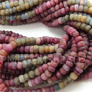 May include: A strand of small, round, multi-coloured gemstone beads. The beads are a mix of pink, red, brown, and grey. The beads are all approximately 4mm in diameter.