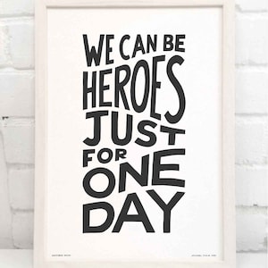 Op de afbeelding: Zwart-wit typografieprint met de tekst "We can be heroes just for one day".