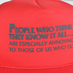 Peut inclure: Casquette de camionneur rouge avec le texte "PEOPLE WHO THINK THEY KNOW IT ALL... ARE ESPECIALLY ANNOYING TO THOSE OF US WHO DO" en gris foncé. Le chapeau a un dos en filet.