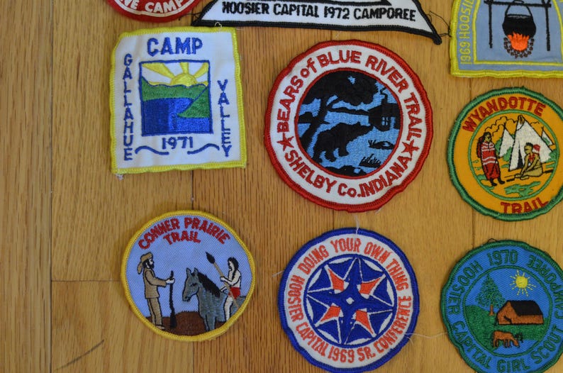 Peut inclure: Une collection de patchs brod&eacute;s color&eacute;s sur le th&egrave;me du camping et du scoutisme. Les patchs comportent des inscriptions telles que "Camp Gallahue Valley", "Bears of Blue River Trail", "Wyandotte Trail", "Conner Prairie Trail" et "Hoosier Capital 1969 Sr. Conference".