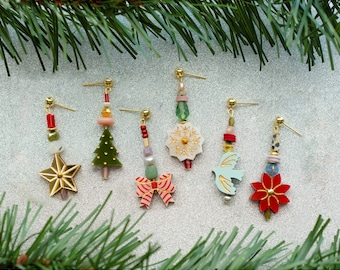 May include: Six pairs of Christmas-themed earrings featuring a variety of designs, including a snowflake, a dove, a Christmas tree, a poinsettia, a bow, and a star. The earrings are made with colorful beads and gold accents.