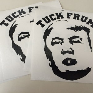 May include: A set of four white vinyl stickers with a black silhouette of Donald Trump's face and the text "F*CK TRUMP" in black.