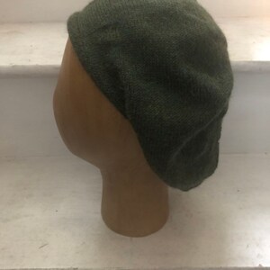 May include: A dark green knitted beret hat.