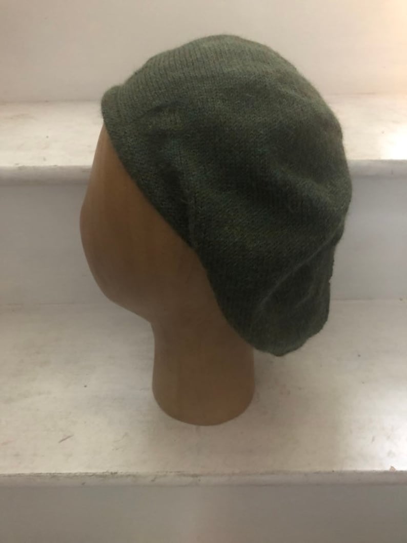 May include: A dark green knitted beret hat.