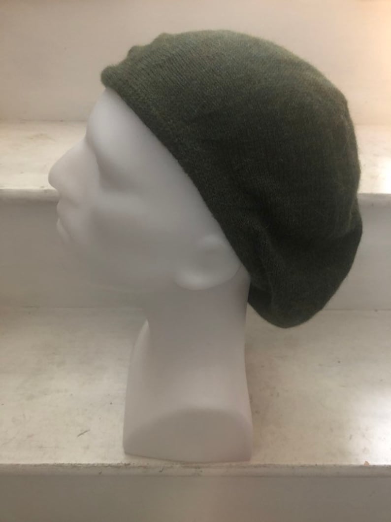 May include: A dark green knitted beret hat.