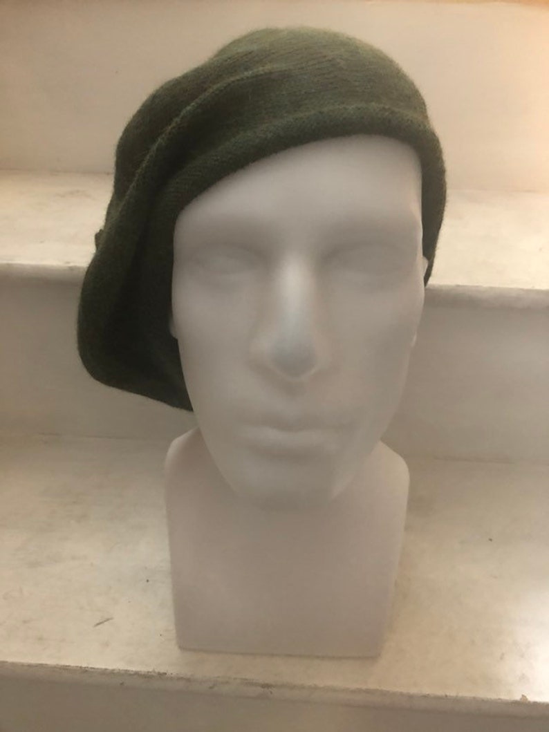 May include: A dark green knitted beret with a folded brim.