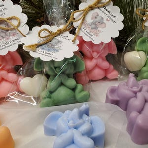 May include: An assortment of colorful elephant-shaped soaps in pink, green, purple, blue, and orange. Some are packaged in clear bags with decorative tags that read "Thank You" and "To Yours!" with a small elephant illustration.