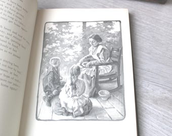May include: An open book featuring a black and white illustration of a person sitting in a rocking chair while two children sit on the floor nearby. The scene is set on a wooden porch with trees in the background, framed by a simple border.