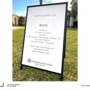 May include: A black metal A-frame sign with a white board displaying the text WHITE BOUNCE CO, RULES, No Shoes, No Food or Drinks, No Pets, No Face Paint, Silly String, Glitter, etc., No Sharp Objects, Stay Off Walls + Netting, Adult Supervision Required, 400 Pound Limit, Bounce Responsibly, and @WHITEBOUNCECO.SWFL. The sign measures 24 inches by 36 inches.