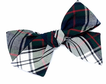 May include: A green, white, red, and blue plaid bow with a white center.