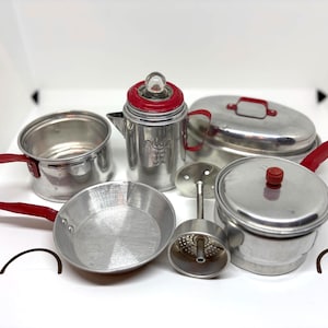 Juego de cocina infantil vintage de 9 piezas de aluminio con mangos rojos: ollas, cafetera y sartenes.