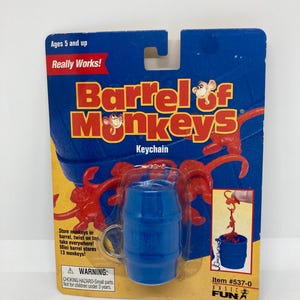 May include: A blue and yellow carded keychain set of Barrel of Monkeys. The card reads "Barrel of Monkeys Keychain" with red monkeys and a blue barrel. The card also includes the text "Ages 5 and up" and "Really Works!"