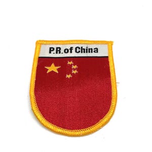 Könnte beinhalten: Ein gestickter Aufnäher in Rot und Gelb mit dem Text "P.R. of China" und einem gelben fünfzackigen Stern und vier kleineren Sternen.