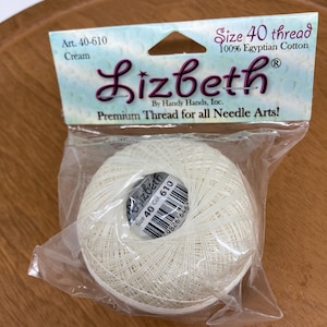 May include: A cream-colored ball of Lizbeth brand size 40 thread, made of 100% Egyptian cotton, packaged in a clear plastic bag. The packaging includes the text "Premium Thread for all Needle Arts!"