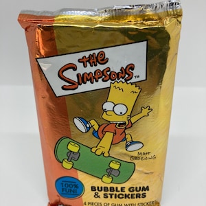 May include: A gold foil packet of "The Simpsons" bubble gum and stickers. The packaging shows Bart Simpson on a skateboard. Text includes "100% FUN!" and "BUBBLE GUM & STICKERS".