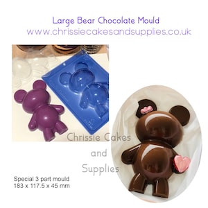 May include: A purple bear-shaped chocolate mold and a finished chocolate bear with a pink heart. The mold is blue and has two bear cavities. The text reads "Large Bear Chocolate Mould" and "Special 3 part mould 183 x 117.5 x 45 mm."