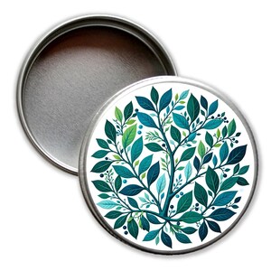 Könnte beinhalten: Eine runde Metalldose mit weißem Hintergrund und einem blauen und grünen Blumendesign. Das Design zeigt einen stilisierten Baum mit Blättern und Beeren.