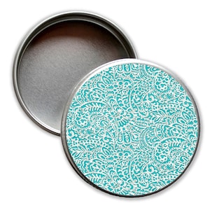 Könnte beinhalten: Eine runde Metalldose mit einem türkisfarbenen und weißen Paisley-Muster auf dem Deckel. Die Dose ist leer und bereit zum Befüllen.