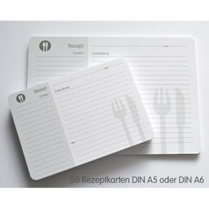 May include: A stack of 50 blank recipe cards in white with gray lines and a gray fork and knife icon. The text "Rezept" and "Zutaten" are printed on the cards. The text "50 Rezeptkarten DIN A5 oder DIN A6" is printed below the cards.
