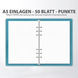 May include: A blue A5 notebook with a silver binding and dotted paper. The notebook has 50 sheets of 100gsm paper. The text on the cover reads "A5 EINLAGEN - 50 BLATT - PUNKTE 100g/m&sup2; PAPIER | 6er Lochung | 2er Lochung | Ungelocht | Eckenabrundung".
