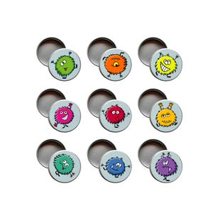 Könnte beinhalten: Neun runde, hellblaue Blechdosen mit Cartoon-Monster-Designs. Jedes Monster hat eine andere Farbe, darunter Grün, Orange, Gelb, Rosa, Rot und Lila. Die Monster haben verschiedene Ausdrücke und sind von einer weißen Kontur umgeben.