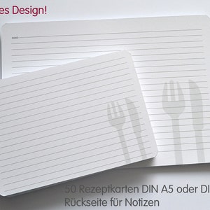 May include: A stack of 50 white recipe cards with lined paper and a gray fork and knife design. The text on the cards reads "50 Rezeptkarten DIN A5 oder DIN A6 R&uuml;ckseite f&uuml;r Notizen".