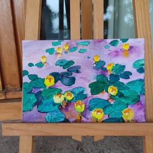 May include: Watercolor painting of yellow water lilies on a purple background. The lilies are surrounded by green lily pads and leaves. The painting is signed "7U Hangut O."