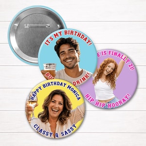 May include: Three circular pin-back buttons featuring custom photo prints. One button shows a man with text "IT'S MY BIRTHDAY! BUY ME A DRINK!", another shows a woman with "LIFE IS FINALLY 21! HIP HIP HOORAY!", and the third says "HAPPY BIRTHDAY MONICA CLASSY & SASSY".