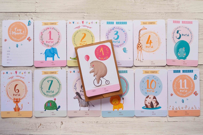 May include: A set of 11 colorful cards with illustrations of animals and the text "Oggi compio" and "mesi" (meaning "Today I turn" and "months"). The cards are numbered 1 through 11, with each card featuring a different animal.