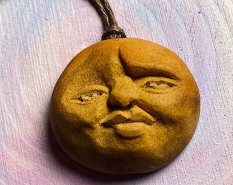 Handcarved avocado pit necklace. Face with raised eyebrow. Natural jewelry.