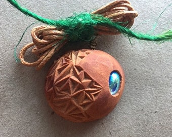 Hand carved avocado stone necklace with rainbow colored irrediscent glass bead.