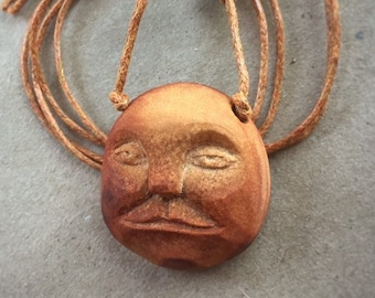 Apathetic face. Hand carved avocado pit necklace. Natural jewelry.