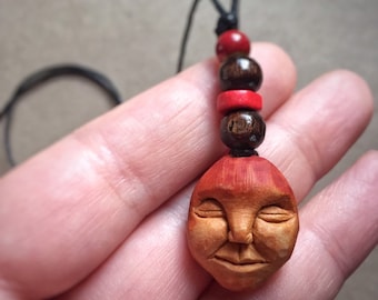Carved avocado pit necklace with wooden beads. Pendant. Face. Natural jewelry.