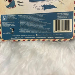 May include: A product package featuring illustrations of Disney characters Minnie Mouse and Goofy. The package includes text in multiple languages, warnings, and a barcode. The product is manufactured by Super7 Retail, Inc.