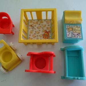May include: A collection of vintage Fisher-Price toy furniture in primary colors. Includes a red chair, yellow crib, blue changing table, red table, yellow stroller, and blue cabinet. The crib has a patterned interior with a teddy bear.