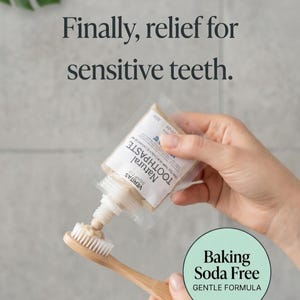 May include: A tube of Veritas Natural Toothpaste being squeezed onto a bamboo toothbrush. The image includes text that reads "Finally, relief for sensitive teeth." and "Baking Soda Free, Gentle Formula."