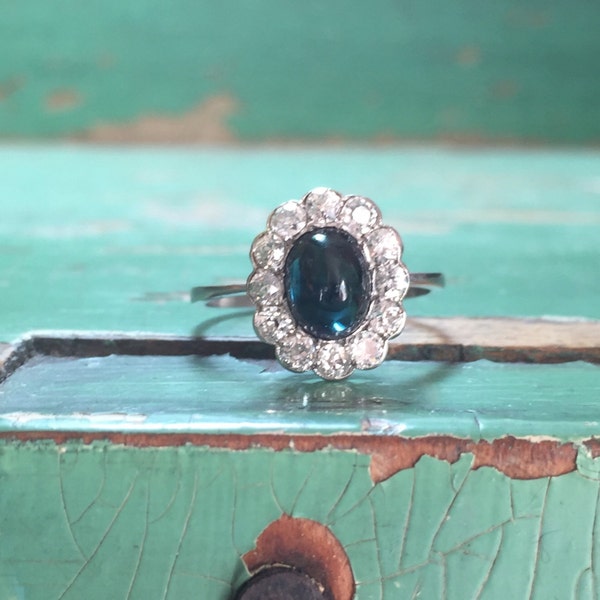 Cabochon green and blue sapphire in platinum halo setting