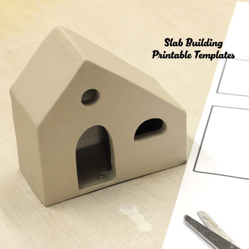 May include: A beige clay house model with three cut-out windows. The house is sitting on a white surface next to a sheet of paper with the text "Slab Building Printable Templates".