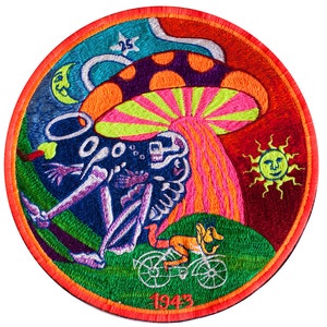 Puede incluir: Un parche circular bordado con un diseño psicodélico. Presenta un esqueleto sentado debajo de un hongo con un sol y una luna en el fondo. El texto "1943" está en la parte inferior del parche.