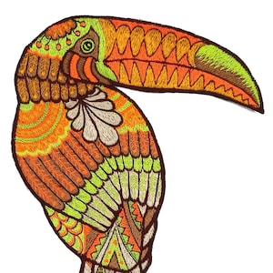 Op de afbeelding: Een kleurrijk geborduurd toucan-patch met oranje, bruin, groen en witte details. De toucan kijkt naar rechts en heeft een grote snavel.