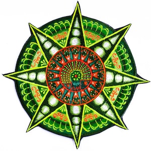 Puede incluir: Parche bordado con un diseño simétrico. El parche presenta un elemento circular central en rojo y verde azulado, rodeado por un patrón de estrella verde y amarillo. El diseño está detallado con costuras intrincadas y un fondo blanco.