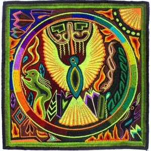 Pode incluir: Têxtil quadrado bordado com um pássaro central com asas abertas, rodeado por um desenho circular. A obra de arte utiliza cores vibrantes como verde, laranja, amarelo e roxo, com um fundo castanho escuro e uma borda verde.