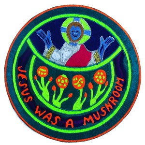 May include: Embroidered patch with a circular design. The patch features a blue figure with a halo, red and white robes, and the text "JESUS WAS A MUSHROOM" in orange. The design includes orange mushrooms with green stems and a green border.