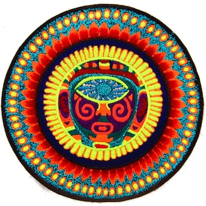May include: Embroidered circular patch featuring a stylized face with an eye, surrounded by concentric rings of color. The design incorporates vibrant hues of blue, orange, yellow, and purple, creating a striking visual effect. The patch is likely for decorative purposes.