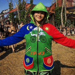 May include: A vibrant hooded jacket with blue, green, and red sections. The green central panel displays a bicycle design and the number "1943". The jacket has two front pockets and a green hood. The sleeves are blue and red.