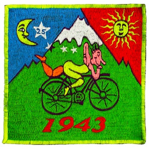 Puede incluir: Parche bordado con un diseño caprichoso. Una figura en bicicleta se establece contra un telón de fondo de montañas, un sol sonriente y una luna creciente. El parche incluye el número "25" y el año "1943" en rojo.